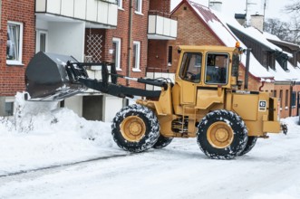 Loader clearing snow on streets in Ystad, Skåne County, Sweden, Scandinavia