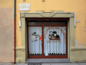 Italy, village of Brescello, advertisement for Pizzeria Pasquale, with a picture of Don Camillo and