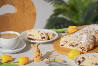 Breakfast table with coffee, sliced yeast braid and decoration for Easter