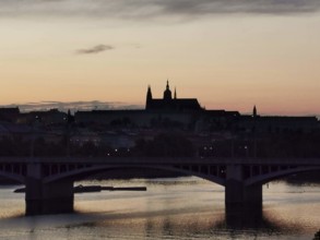 Pink sunset over the Vltava with silhouettes of Charles Bridge and Hradcany, Prague, Czech Republic