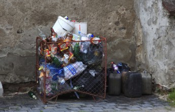 Full garbage container and canister on a corner of a house, garbage, trash, Transylvania, Romania