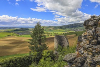 Ruins in front of a wide view of fields and hills under a cloudy blue sky, Mägdeberg Castle Ruins,