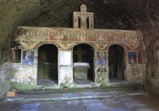 Corbii de Piatra rock monastery, stone ravens carved into a massive, 30-meter high sandstone wall,