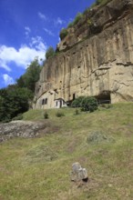 Corbii de Piatra rock monastery, stone ravens carved into a massive, 30-meter high sandstone wall,