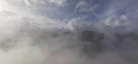 Thick blanket of clouds and fog over a mountain landscape with mystical sky, hiking in the High