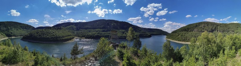 Panoramic view of Leibis Reservoir surrounded by forests and hills under a blue sky, hiking in the
