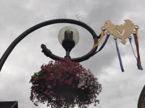Decorative street lamp with flowers and a heart under cloudy sky, Zakopane, hiking in the High