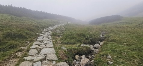 Rocky hiking trail through hilly, foggy landscape, Zakopane, hike to Kasprowy Wierch in the High