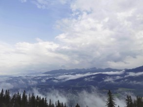 Extensive view of a foggy valley with mountains and cloud cover in the background, Zakopane, hiking
