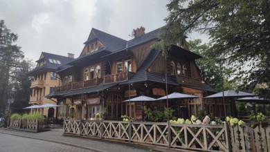 Charming restaurant in traditional Zakopane Tatra wood style with terrace and garden fence,