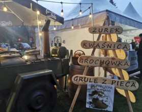 Street vendor with goulash cannon with traditional Polish food at night, illuminated with warm