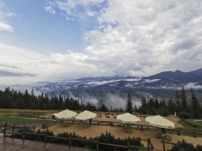 Mountain panorama with clouds, conifers and leisure area, huts and wide sky, Gubalowka, Zakopane,