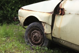 Car wreck, flat tire on rusty rim, rust, junk car