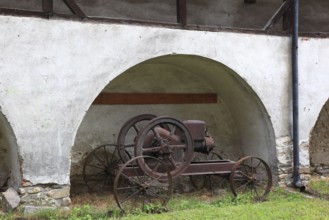 Old agricultural equipment within the defensive wall of the fortified church of Valea Viilo, German