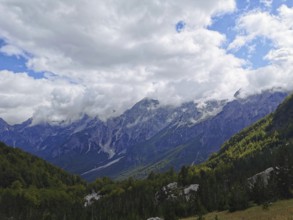 Mountain landscape with thick clouds and extensive forests in daylight, Peaks of the Balkans,