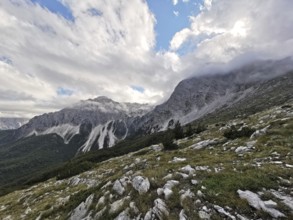 View of a mountainous landscape with dramatic clouds and rocks in the foreground, Peaks of the