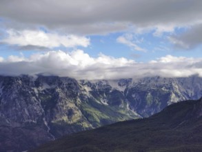 Fascinating mountain landscape with clouds floating over the peaks and light play in the sky, Peaks