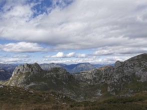 Mountain panorama, impressive rock massif under a dynamic cloudy sky in wild surroundings, Peaks of
