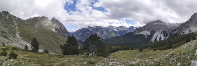 Extensive mountain panorama with forests between rocky peaks and clouds, Peaks of the Balkans,