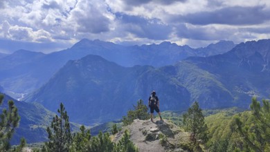 Hikers on peaks with views of mountain scenery and dramatic skies, Peaks of the Balkans, hiking in