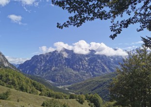 Extensive mountain landscape with idyllic valley and dramatic cloud formation, Peaks of the