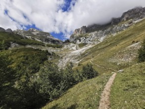 Trail through a mountainous landscape with dramatic clouds in the sky, Peaks of the Balkans, hiking