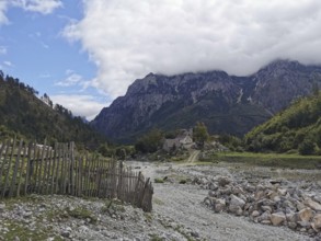 Rocky area and fences lead to a small village in an alpine environment, Peaks of the Balkans,