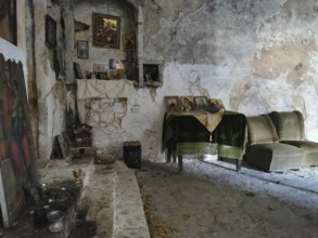 Atmospheric interior view of an abandoned Orthodox chapel with icons and dilapidated walls, Himare,