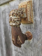 Close-up of a rusty antique door knocker in the shape of a hand, Berat, Albania