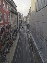 View from above of a long, empty city street with tram tracks, Lisbon, Portugal