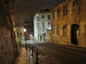 Night view of a picturesque street with cobblestones and buildings illuminated by lamps, tracks of
