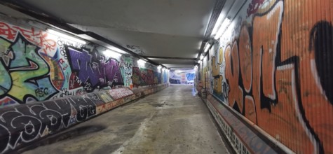 Long tunnel with colorful graffiti on the walls, urban flair, metro, Lisbon, Portugal