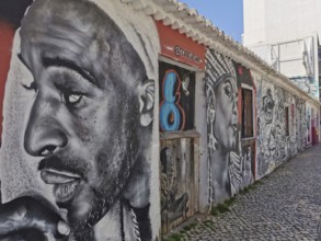 Wall with large-format graffiti in black and white of several expressive faces, Lagos, Algarve,