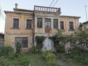 Dilapidated, overgrown historic building with an overgrown garden, old villa, Georgia