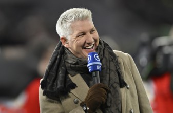 TV expert Bastian Schweinsteiger, portrait, smiles, in interview microphone Mikro Logo ARD BR