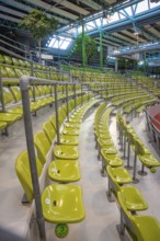 Green seats in a modern sports hall, arranged in rows along a grandstand, Sindelfingen Glass