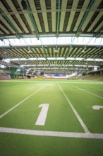 Interior view of a large sports hall with green running track and stands, Sindelfingen Glass
