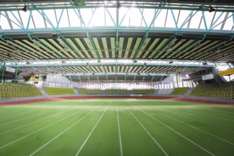 Extensive sports hall with green running track, surrounded by large windows, Sindelfingen Glass