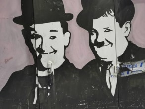 Black and white wall painting, graffiti, two smiling comedians, fat and stupid, Tirana, Albania