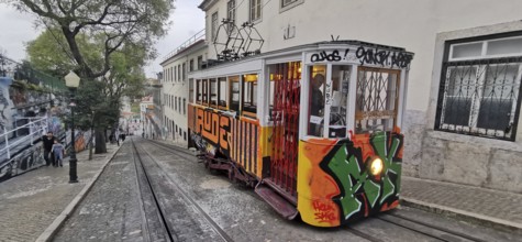 Historic funicular, Elevador da Gloria with graffiti goes down a steep road, Lisbon, Portugal