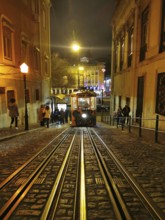A busy scene with a tram on illuminated cobblestone streets at night, funicular, Lisbon, Portugal