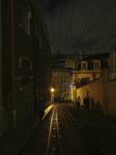 Rails of the Elevador da Gloria funicular, A dark alley at night with lantern light and shadows