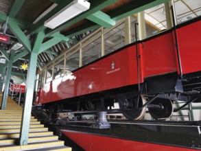 A red mountain railway is located in a wooden station, stairs lead up, Oberweissbach cable car,