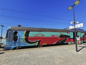 A train painted with graffiti stands on a sunny platform, Lagos, Algarve, Portugal