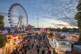 Ferris wheel, chain carousel, food stalls and visitors at the Cannstatter Volksfest, Cannstatter