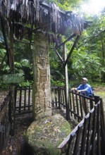 Guatemalan man from the Mayan people looks at a hieroglyphic stele in the Seibal or El Ceibal