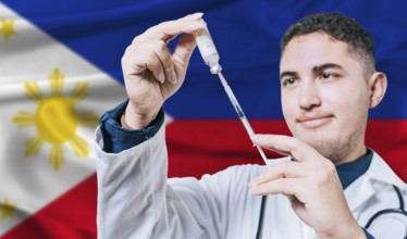 Doctor holding syringe on Philippines flag background. Medical professional holding syringe with