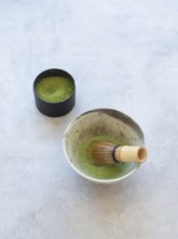 Freshly prepared matcha green tea with a bamboo whisk and powdered tea