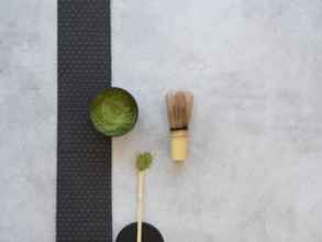Matcha powder in a bowl with bamboo chasen whisk, preparing traditional green tea