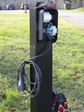 Electric vehicle charging station showing internal wiring during installation process